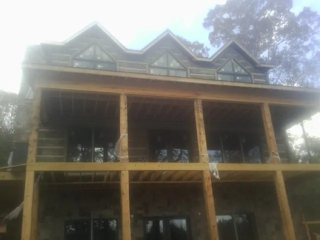 Dormers and porch framing on a large log home under construction — Roof Coating work by our crew in Gardiner